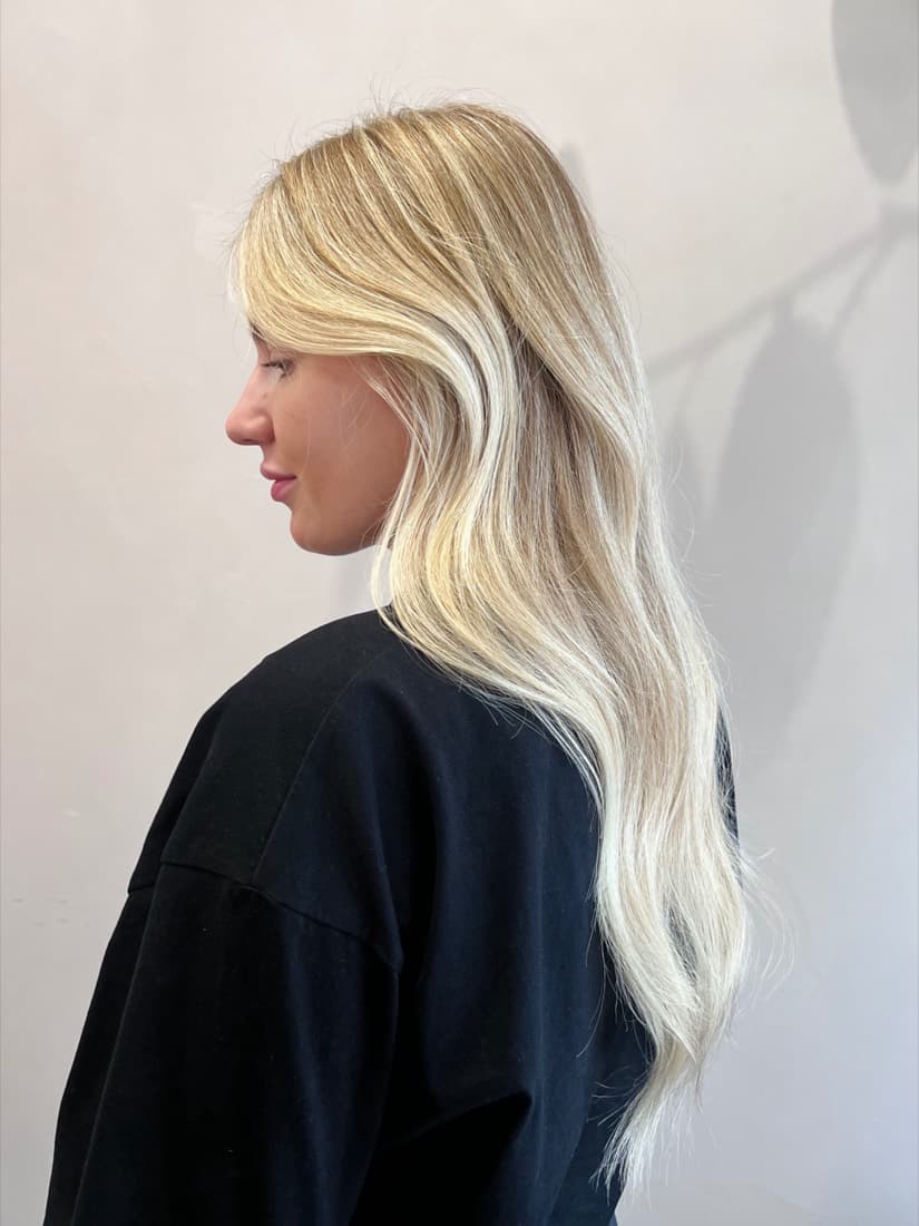 Profile view of a bright, cool-toned blonde with seamless root-to-end transition