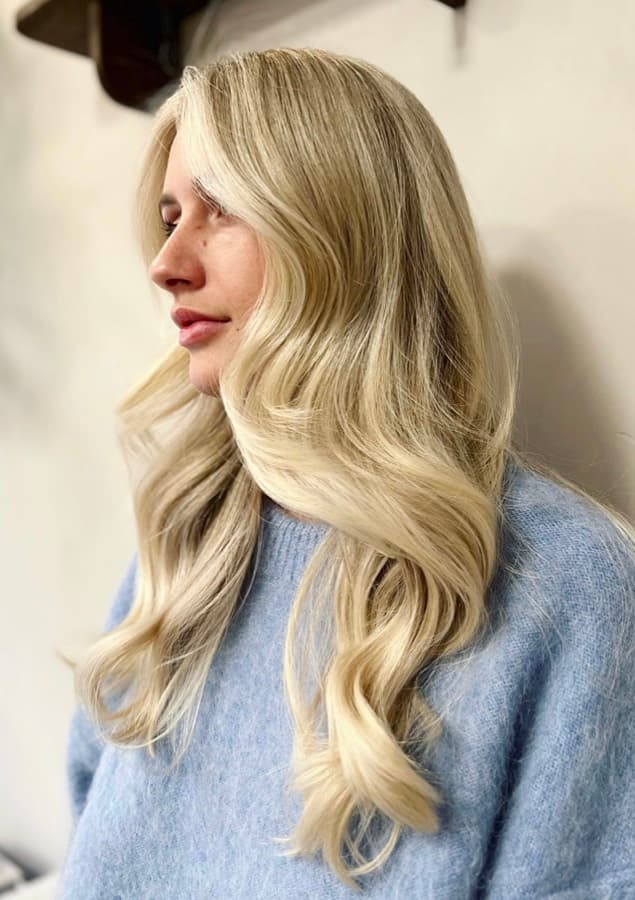 Soft golden blonde with lived-in dimension, styled in loose waves